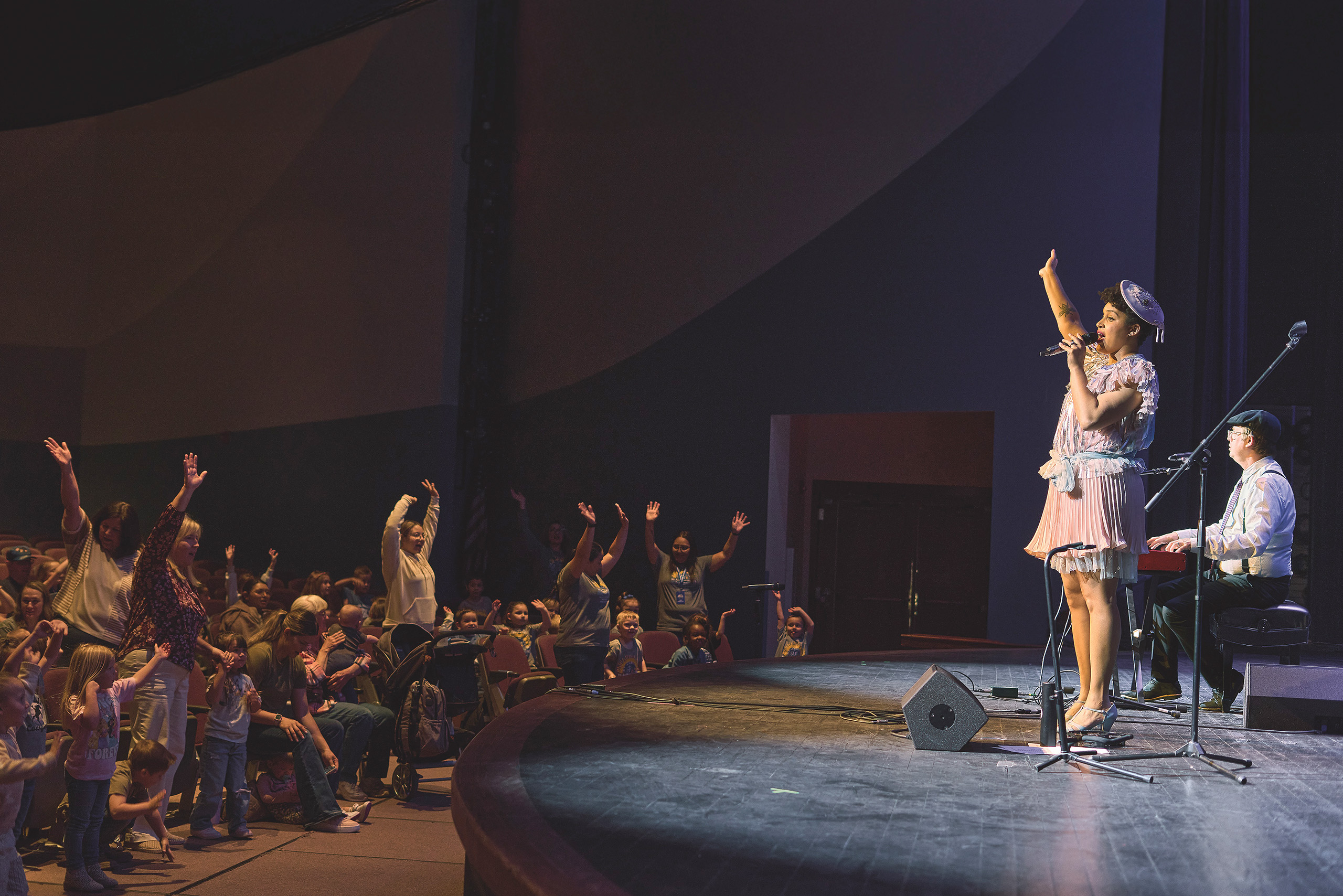 Performer Jazzy Ash performs for an audience of children, caregivers, and teachers.